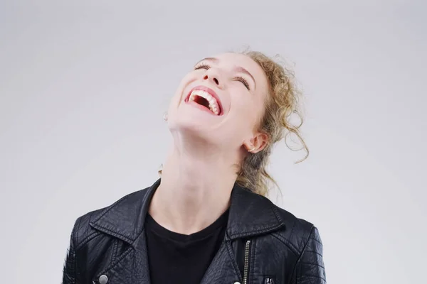 Leben Sie ein wenig. Lacht viel. Studioaufnahme einer attraktiven jungen Frau, die vor grauem Hintergrund lacht. — Stockfoto
