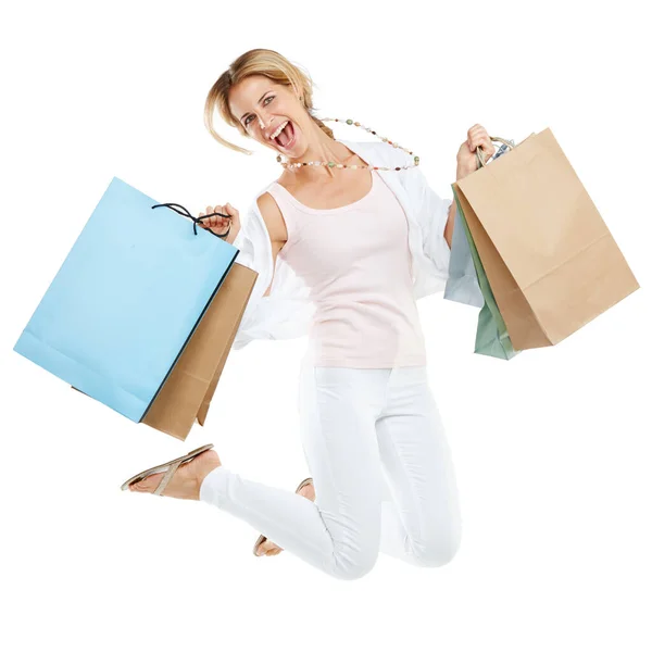 Il caos dello shopping in pieno svolgimento. Studio ritratto di una giovane donna eccitata che trasporta borse della spesa e salta per la gioia su uno sfondo bianco. — Foto Stock