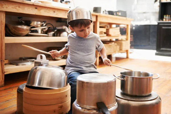 Рок-звезда в процессе создания. Мальчик играет на барабанах на кастрюлях и сковородках. — стоковое фото