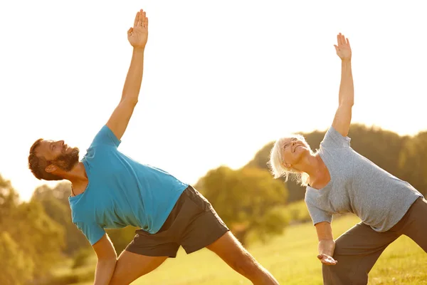 Yoga-Lebensstil. Schuss eines reifen Paares beim gemeinsamen Yoga im Freien. — Stockfoto