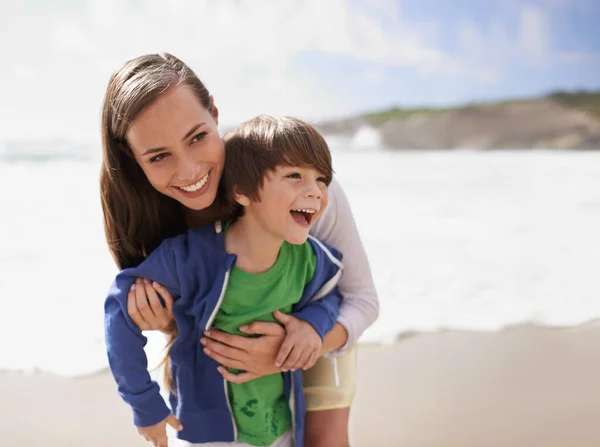 Solletico solletico. Girato di una giovane madre che gioca con suo figlio in spiaggia. — Foto Stock