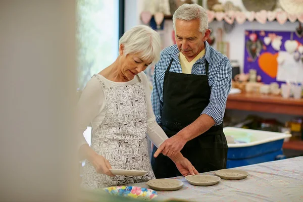 Es un patrón interesante en ese plato. Fotografía de una pareja mayor trabajando con cerámica en un taller. — Foto de Stock