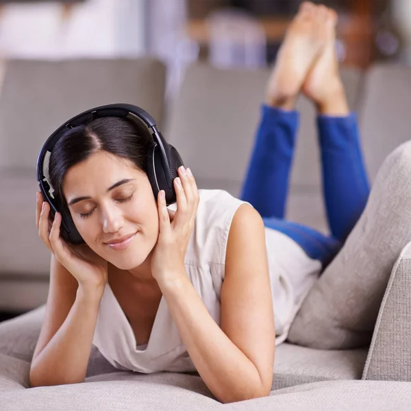 Mi sto dando da fare. Girato di una giovane donna che ascolta musica mentre si rilassa a casa. — Foto Stock