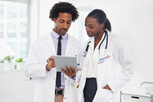 Este é o diagnóstico correto. Tiro de dois médicos de pé em uma sala usando um tablet digital. — Fotografia de Stock