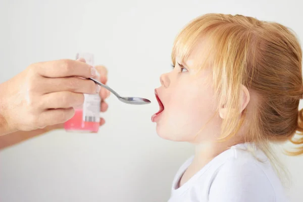 C'est une fille qui grandit. Une jolie petite fille avec sa bouche ouverte pour être nourrie avec une cuillère. — Photo