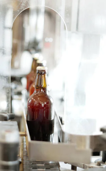 A delicious new brew. Shot of beer bottles on a production line at a brewery. — Stock Photo, Image