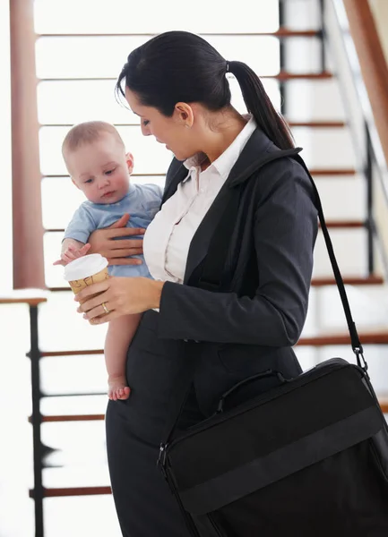 Anyukák az irodába. Dolgozó anya egy aktatáskával a kezében egy kisbabát tart.. — Stock Fotó