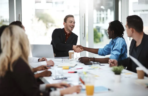 Nieuwe leden verwelkomen in hun dynamische team. Shot van zakenmensen schudden elkaar de hand tijdens een vergadering in een kantoor. — Stockfoto