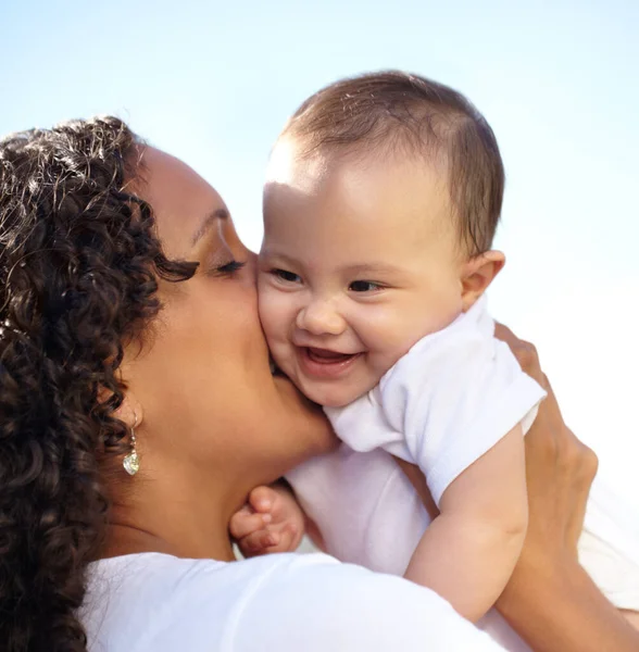 Happy times. Closeup of a young mother holding up and kissing her baby daughter. Royalty Free Stock Photos