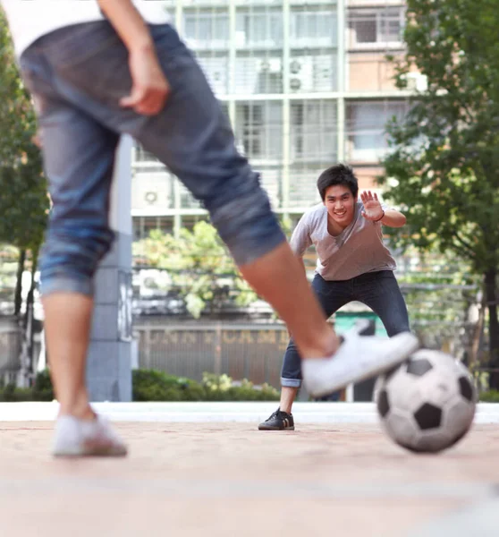 Niemand komt langs hem. Achteraanzicht van een speler die klaar is om een voetbal te schoppen terwijl de keeper klaar staat. — Stockfoto