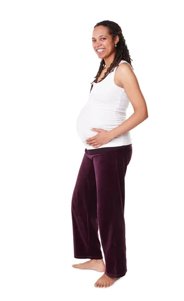 Emocionado com a maternidade. Uma mulher afro-americana grávida feliz sorrindo para a câmera enquanto segura o estômago - isolada. — Fotografia de Stock