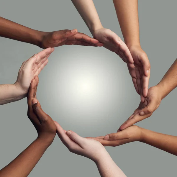 Samenkomen om er één te vormen. Gesneden opname van een groep handen die zich verbinden tot een cirkel tegen een grijze achtergrond. — Stockfoto