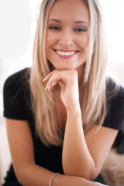 O sorriso dela deixa toda a gente à vontade. Retrato de uma jovem sentada com a mão no queixo. — Fotografia de Stock