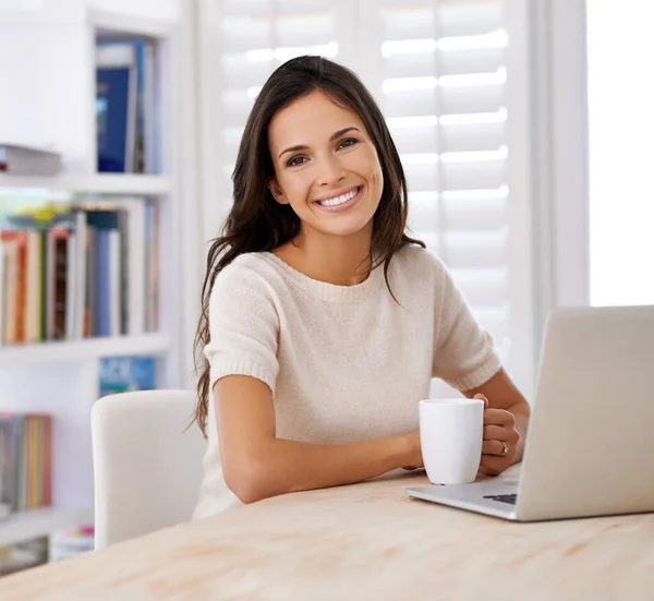 Online all the time. Portrait of an attractive young woman using her laptop at home. — Stock Photo, Image