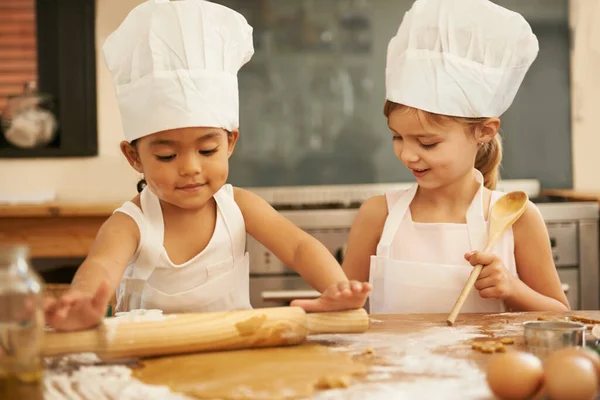 Memanggang sangat menyenangkan. Dua gadis kecil memanggang bersama di dapur. — Stok Foto