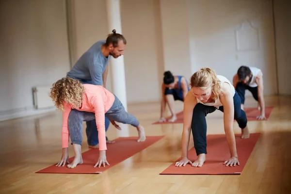 Tu instructor de yoga es la clave para una clase exitosa. Foto de un instructor de yoga guiando a uno de sus alumnos. — Foto de Stock
