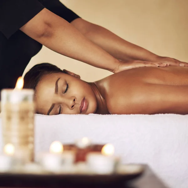 Haar ontspannende plek.... Gesneden shot van een jonge vrouw die een massage krijgt in de spa. — Stockfoto