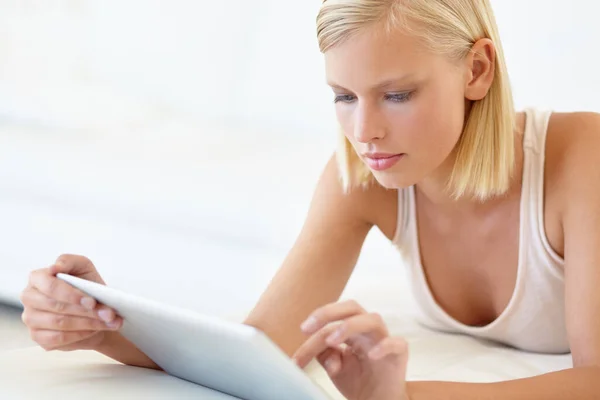 A ler um livro online. Uma jovem mulher trabalhando em seu tablet digital. — Fotografia de Stock