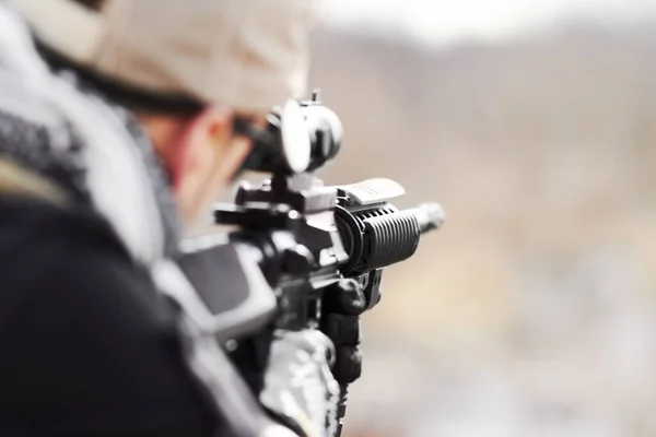 Gericht op zijn doelwit. Achteraanzicht van een scherpschutter die zijn pistool in de verte richt met kopieerruimte. — Stockfoto