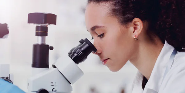 Bleiben Sie neugierig auf die Welt. Aufnahme eines jungen Wissenschaftlers unter dem Mikroskop in einem Labor. — Stockfoto