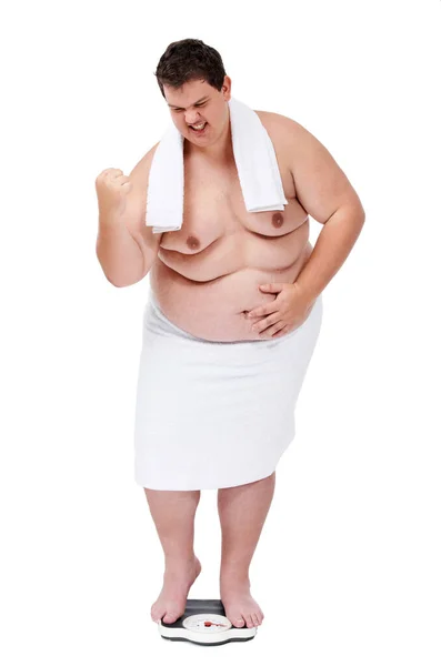Sì, mancano solo altre cento libbre. Un giovane sovrappeso che sembra soddisfatto di se stesso dopo aver pesato su una bilancia. — Foto Stock