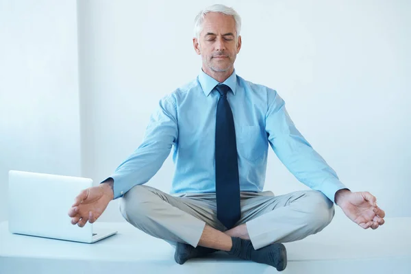 Merkezini bulmak. Olgun bir iş adamının bacak bacak üstüne atıp meditasyon yaptığı uzun bir çekim.. — Stok fotoğraf