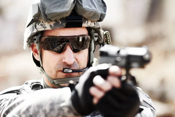 Han har en fokuserande kraft. Närbild huvud och axlar skott av en soldat som pekar sin hand pistol. — Stockfoto