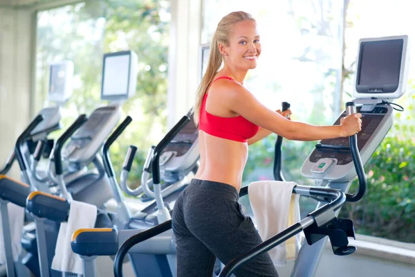 Working on her fine form. Shot of a beautiful young woman working out on a stepping machine.