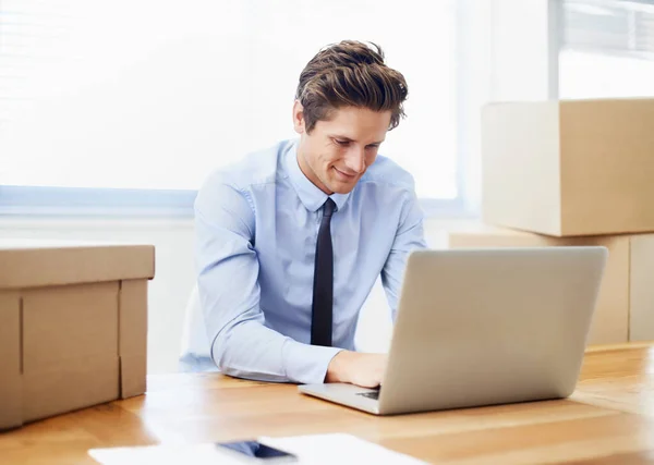 Die Ideen fließen heute... Ein junger Geschäftsmann arbeitet nach einem Bürowechsel an seinem Laptop. — Stockfoto