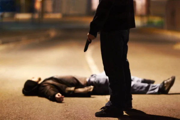 Acts of violence. Man lying on the ground after being shot by a gun-wielding criminal. — Stock Photo, Image