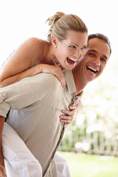 Não te preocupes, apanhei-te. Um tiro cortado de um homem feliz e mulher rindo enquanto ele lhe dá um passeio de carona. — Fotografia de Stock