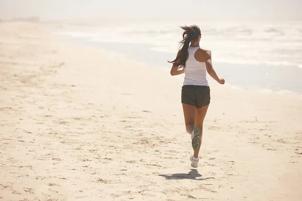 Quando as pernas se cansarem, corre com o coração. Tiro de uma jovem desportiva que se exercita ao ar livre. — Fotografia de Stock