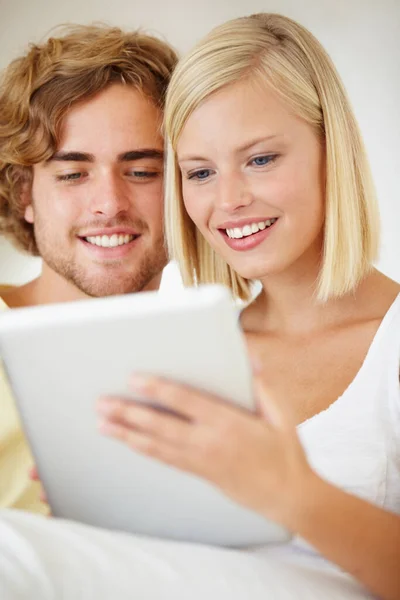 Διαίσθηση χρήστη. Ένα νεαρό ζευγάρι που περιηγείται στο διαδίκτυο στο tablet τους από την άνεση του καναπέ τους. — Φωτογραφία Αρχείου