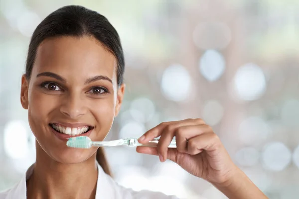 Cepille todos los días para una sonrisa perfecta. Retrato de una mujer sonriente sosteniendo un cepillo de dientes. —  Fotos de Stock