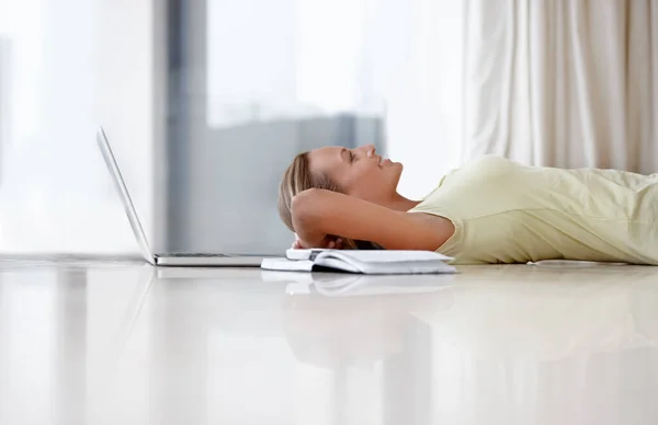 Komfortowe połączenie. Młoda kobieta leżąca na podłodze w domu obok laptopa i notesu.. — Zdjęcie stockowe