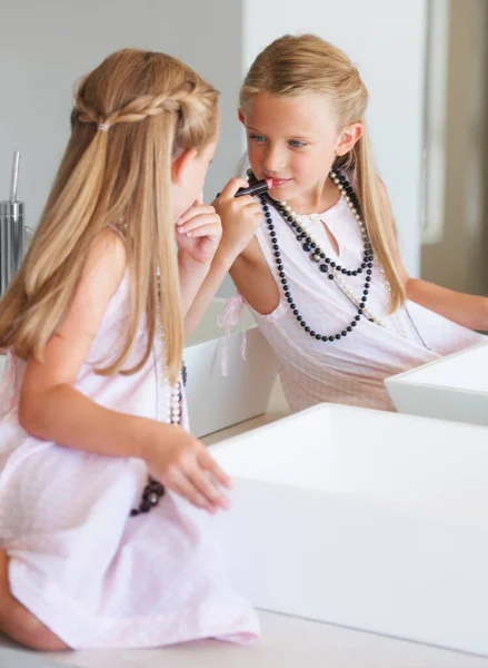 Використовуючи мамину помаду. Маленька дівчинка приміряє макіяж . — стокове фото