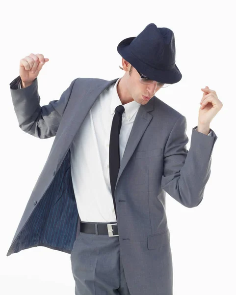 Con un chasquido y barajar. Un joven con traje y sombrero bailando sobre un fondo blanco. —  Fotos de Stock