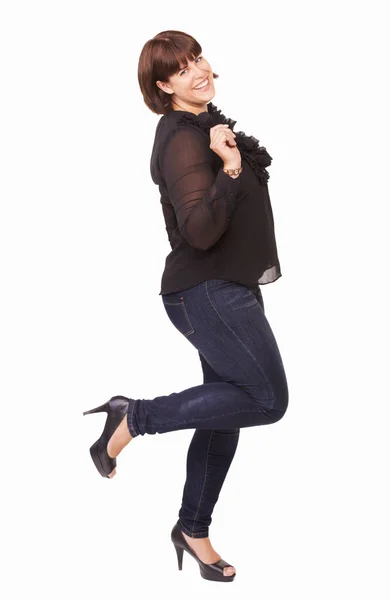 Fun and flirty. Portrait of a playful young brunette woman lifting on foot on a white background. — Stock Photo, Image