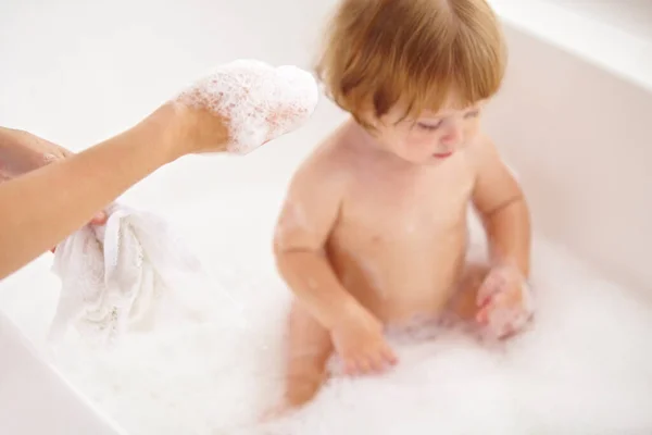 连婴儿都喜欢泡泡浴。拍了一张小女孩被妈妈洗澡的照片. — 图库照片