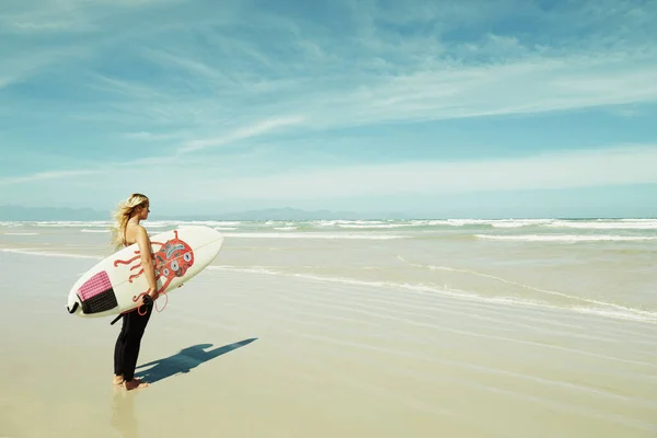 Úton az óceánba. Egy fiatal szörfös lány fogja a szörfdeszkáját.. — Stock Fotó
