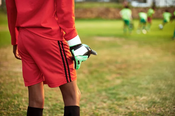 Připraven na jeho záchranu. Detailní záběr mladého chlapce stojící jako brankář při hraní fotbalu na sportovním hřišti. — Stock fotografie