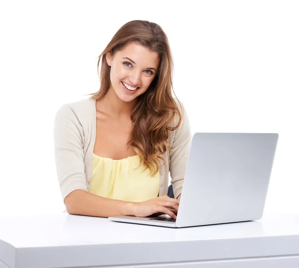 Jak najlepsze wykorzystanie technologii. Studio ujęcie atrakcyjnej młodej kobiety siedzącej przy stole i korzystającej z laptopa. — Zdjęcie stockowe