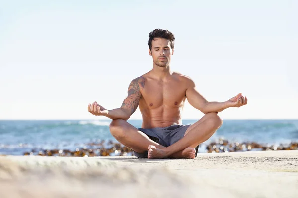 Doğada aydınlanma arayışı. Okyanusun kenarında meditasyon yapan genç bir adam.. — Stok fotoğraf