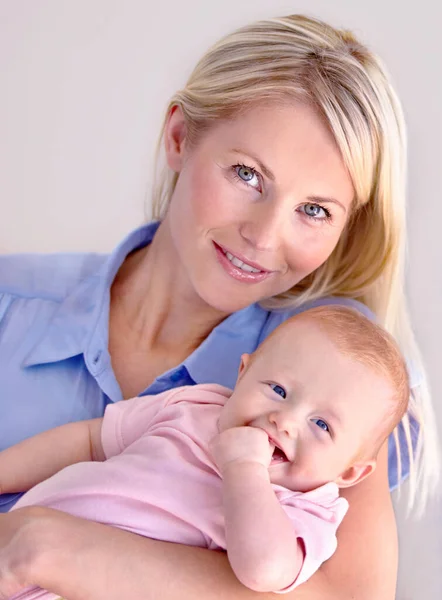 Perfect portret. jong moeder houden haar schattig baby terwijl glimlachen naar de camera. — Stockfoto