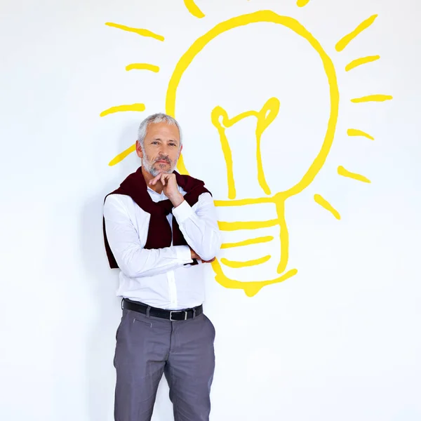 좋은 생각을 가진 사람이야. 백색광을 배경으로 전구를 켜고 서 있는 장성 한 사업가의 모습. — 스톡 사진