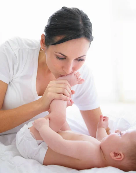 Reichlich Liebe von Kopf bis Fuß. Schöne Frau küsst ihre Babys Füße. — Stockfoto