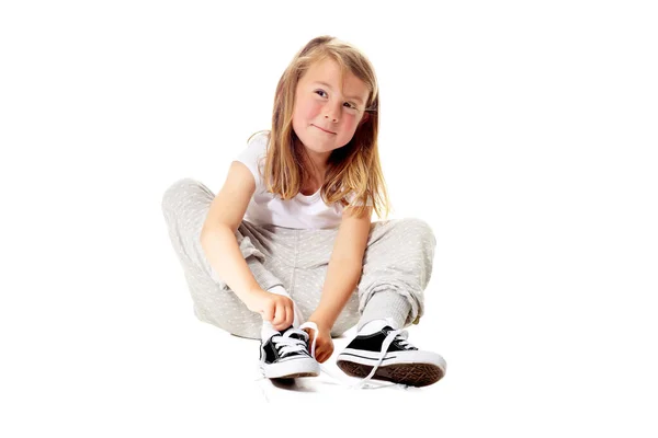 Ты знал, что я умею завязывать шнурки? Снимок милой маленькой девочки, изолированной на белом. — стоковое фото