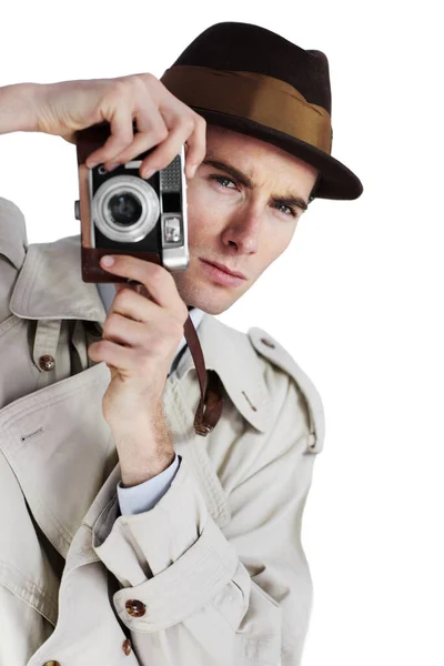 Auf der Suche nach dem richtigen Schuss. Reporter macht ein Foto mit einer Retro-Kamera vor weißem Hintergrund, während er wegschaut. — Stockfoto