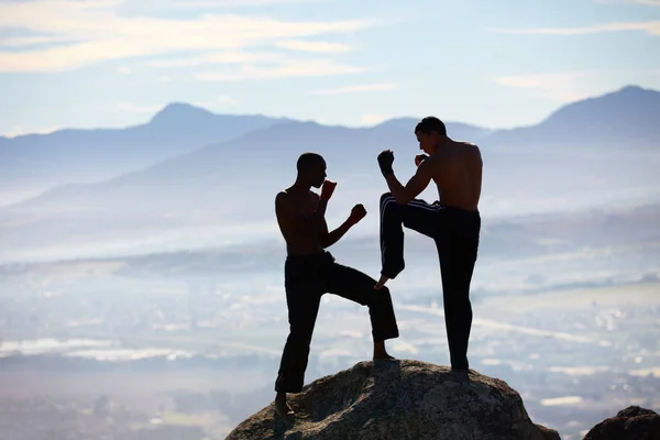 Extrém kickbox. Egy férfi kickboxoló, aki a hegycsúcson gyakorolja a technikáját.. — Stock Fotó
