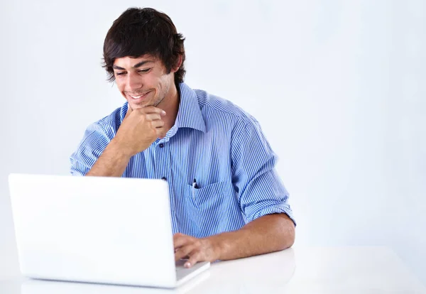 浏览一下网页。拍了一个笑着在笔记本电脑上工作的年轻商人. — 图库照片